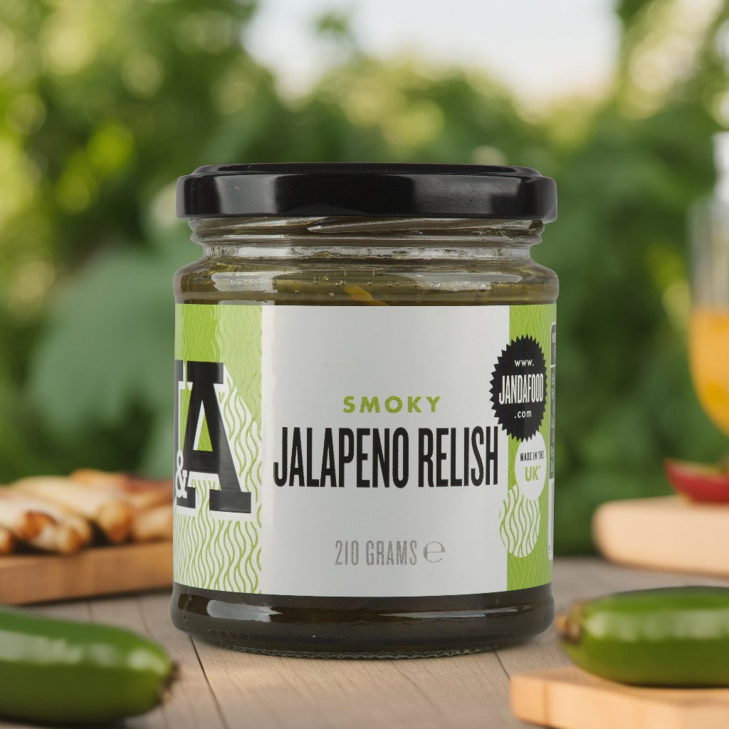 Jar of J&A Smoky jalapeno relish on a wooden surface with blurred greenery in the background
