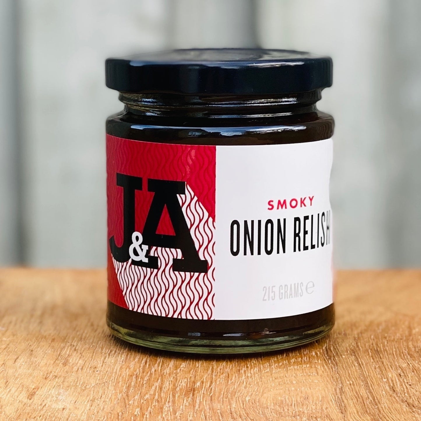 Janda Food smoky onion relish in a glass jar with a red and white label on a wooden surface