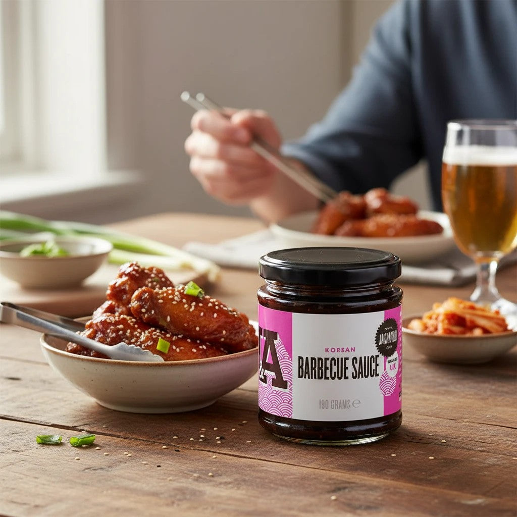 Janda Food Korean Barbecue Sauce in a 190g glass jar served with glazed chicken wings on a wooden table