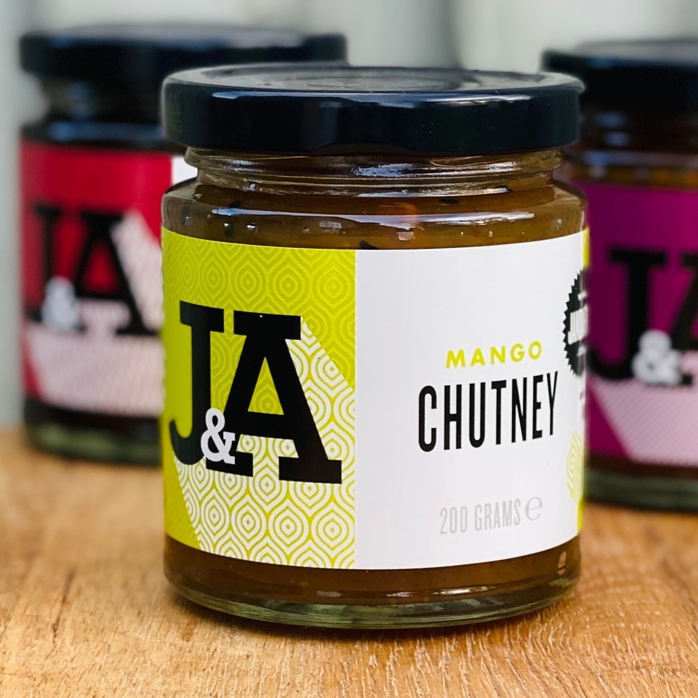 Janda Food Mango Chutney in a 200g glass jar with a modern white and lime green label on a wooden surface.