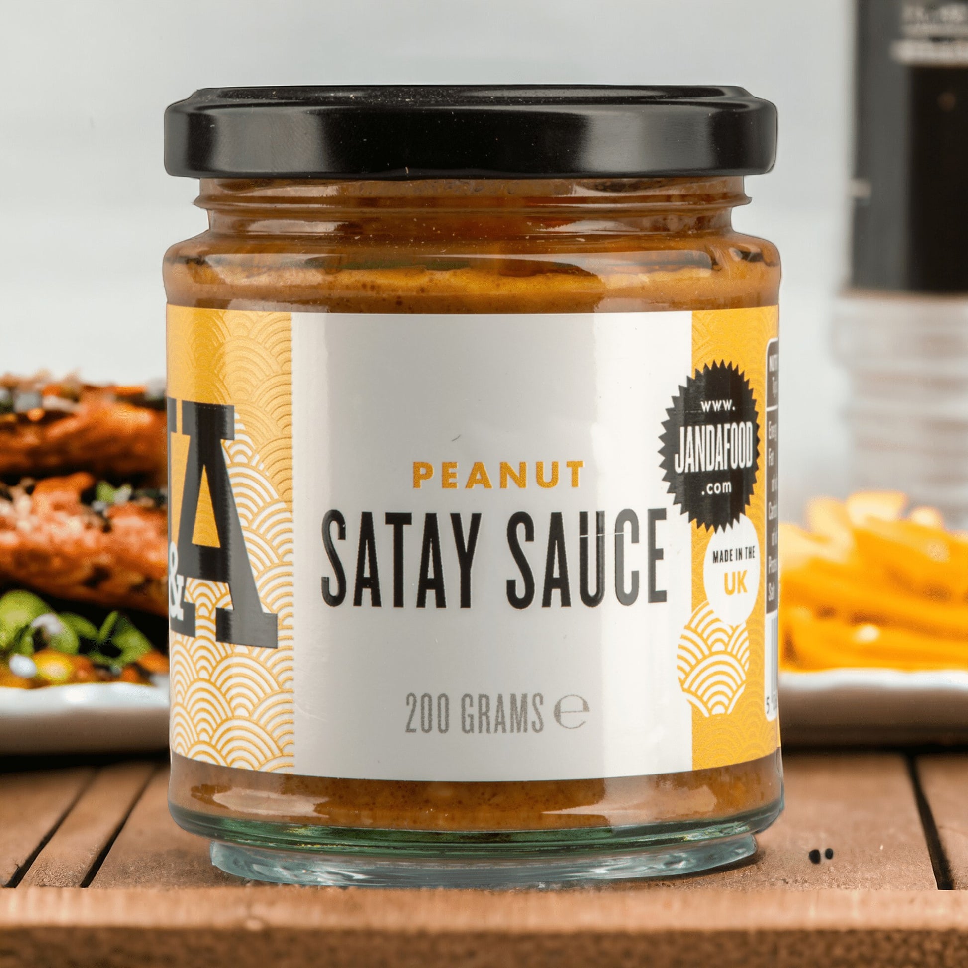 Janda Food Peanut Satay Sauce in a 200g glass jar with a yellow and white label featuring traditional patterns.