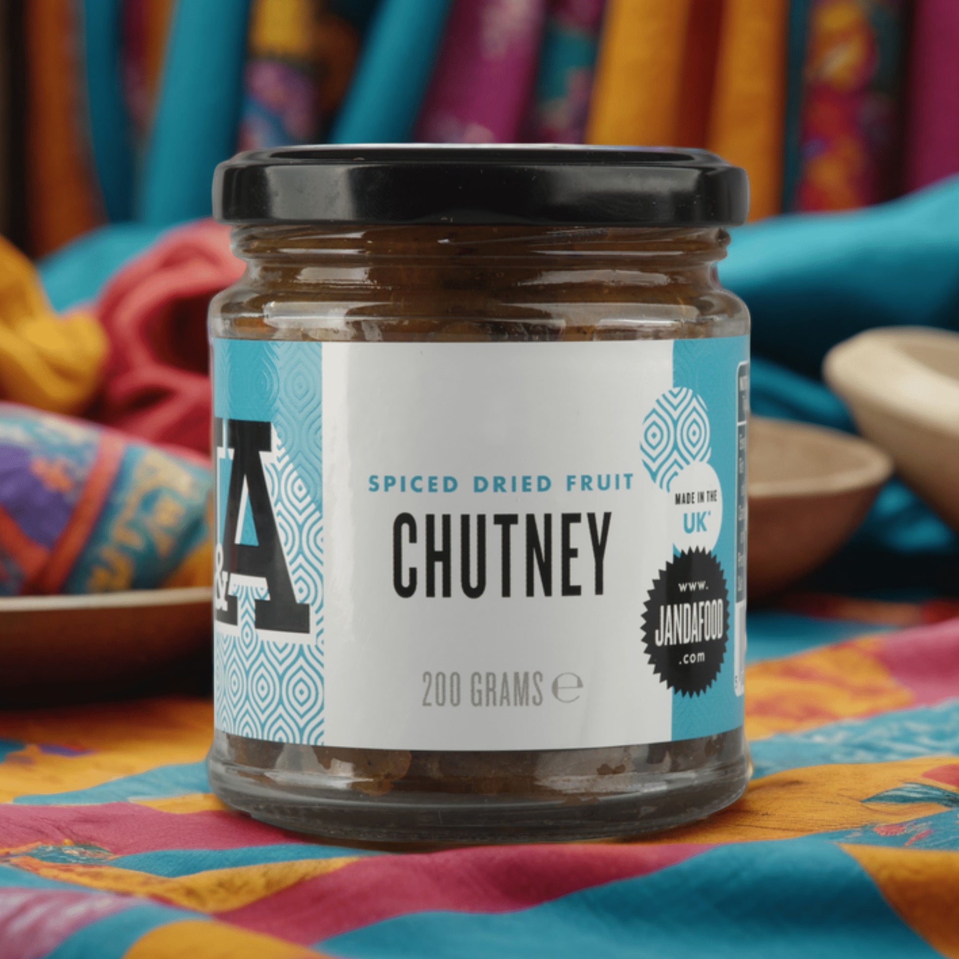 Janda Food 200g jar of spiced dried fruit chutney with a white label, set against a colourful patterned fabric.