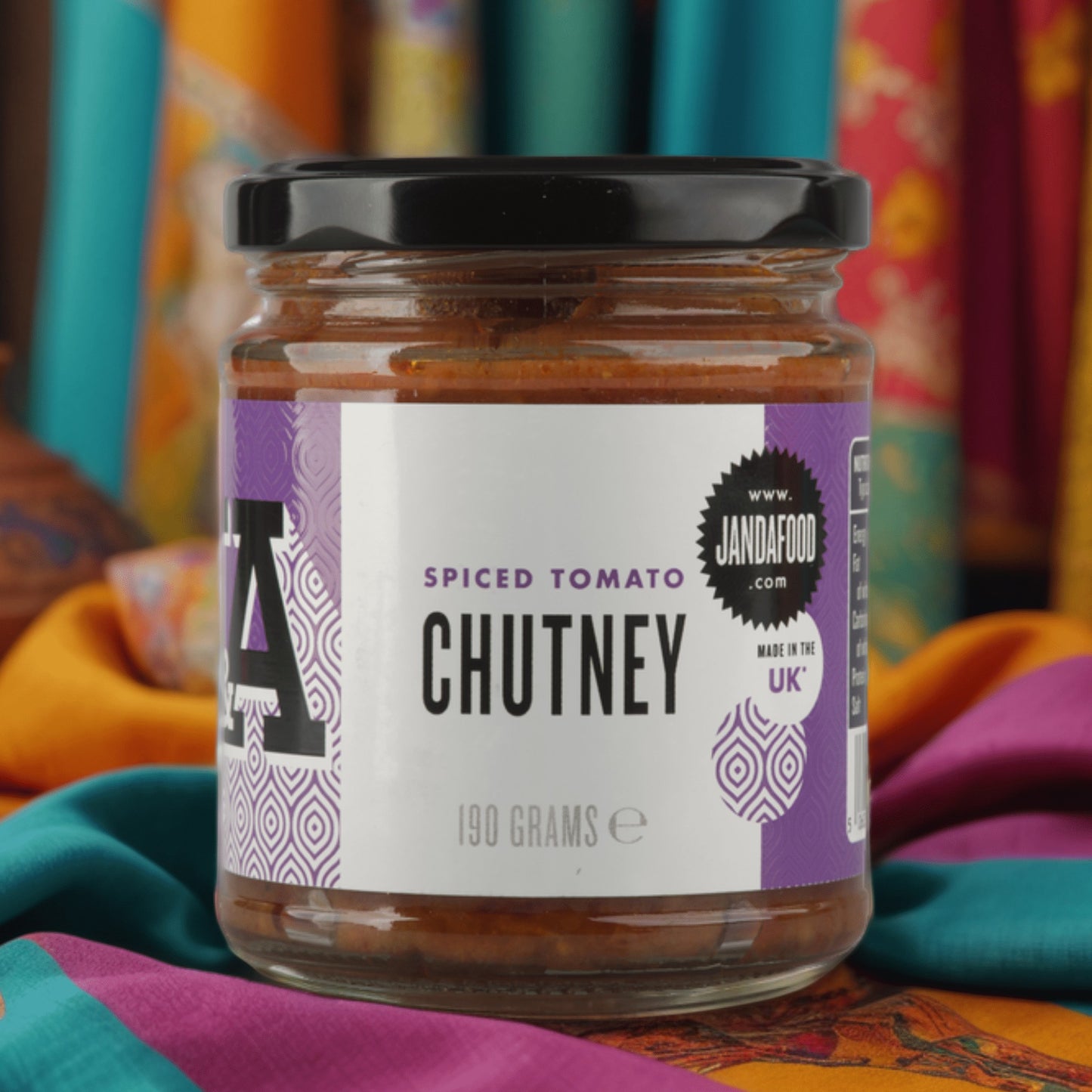 Janda Food spiced tomato chutney in a glass jar with a purple label, featuring a rich, textured tomato base.