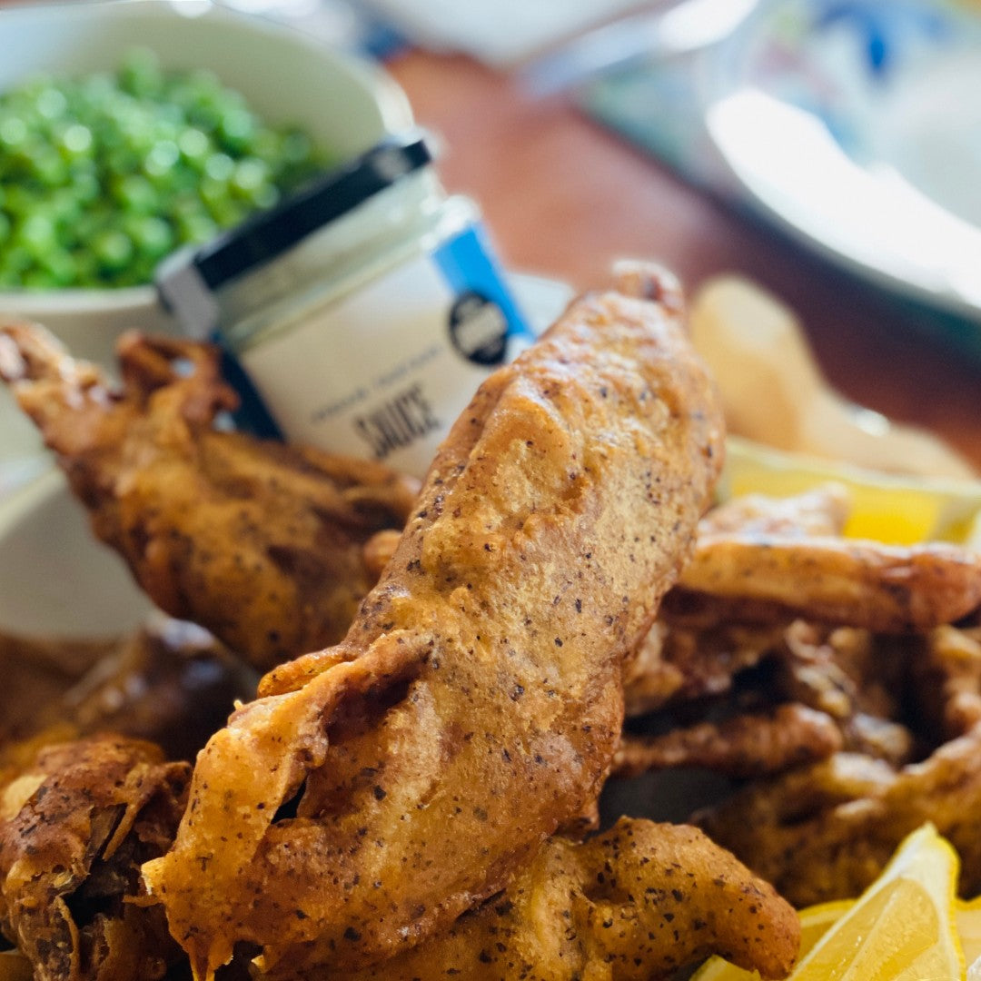 Janda Food vegan tartare sauce jar served alongside crispy vegan fish and chips with lemon wedges and peas