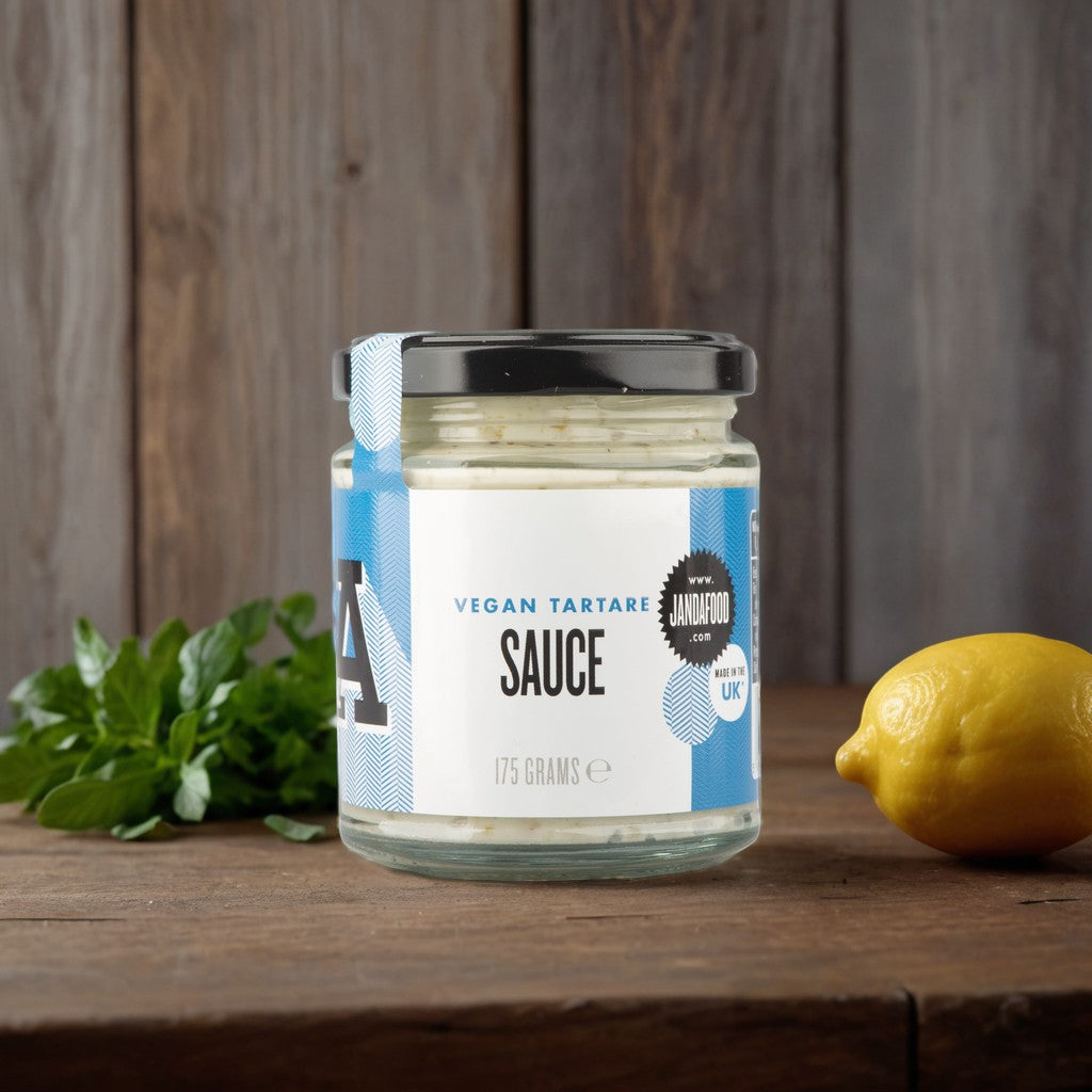 Janda Food vegan tartare sauce in a glass jar with fresh lemon and herbs on a rustic wooden table